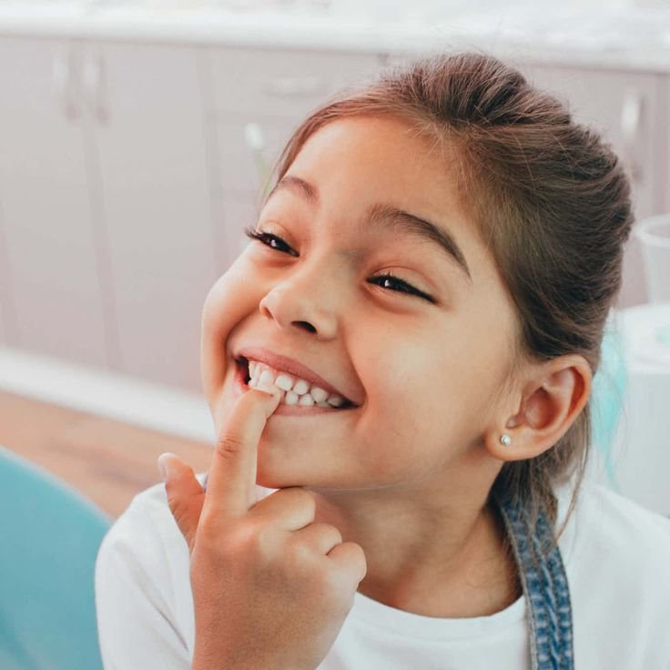 Child smiling confidently as part of a positive oral-care journey